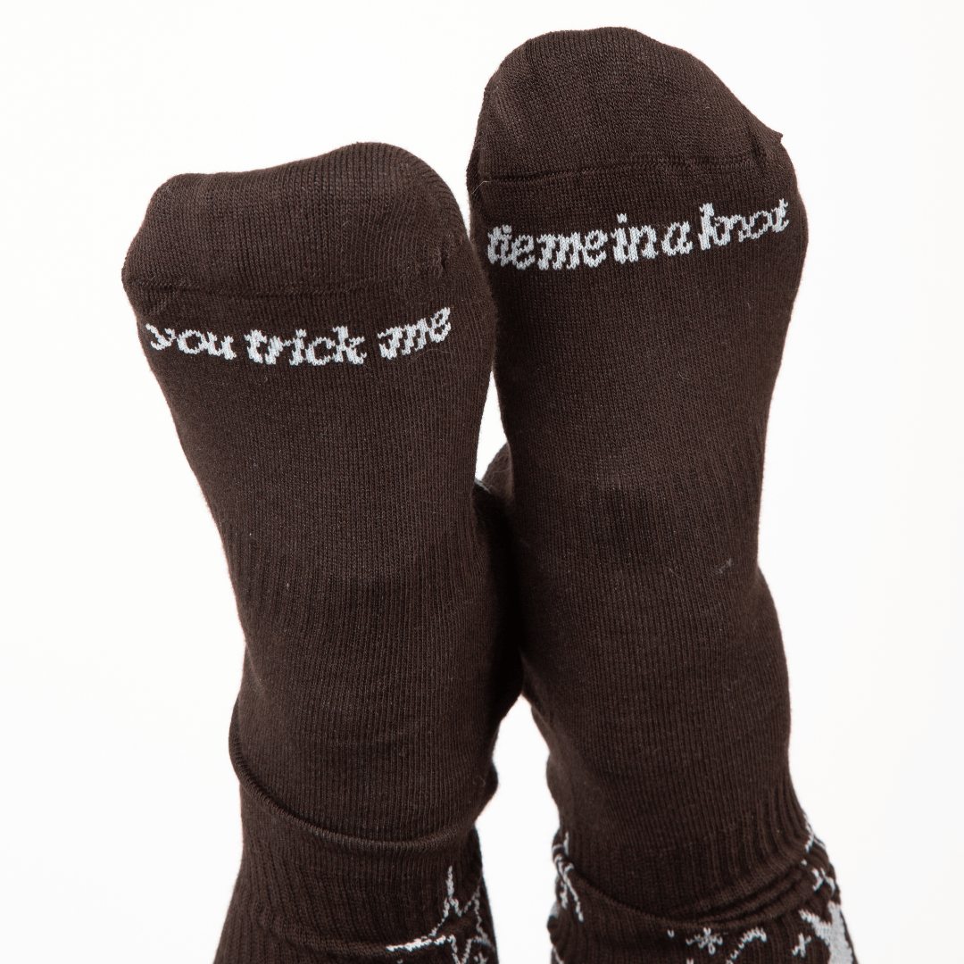 Pair of dark brown socks with white text and patterns on a white background